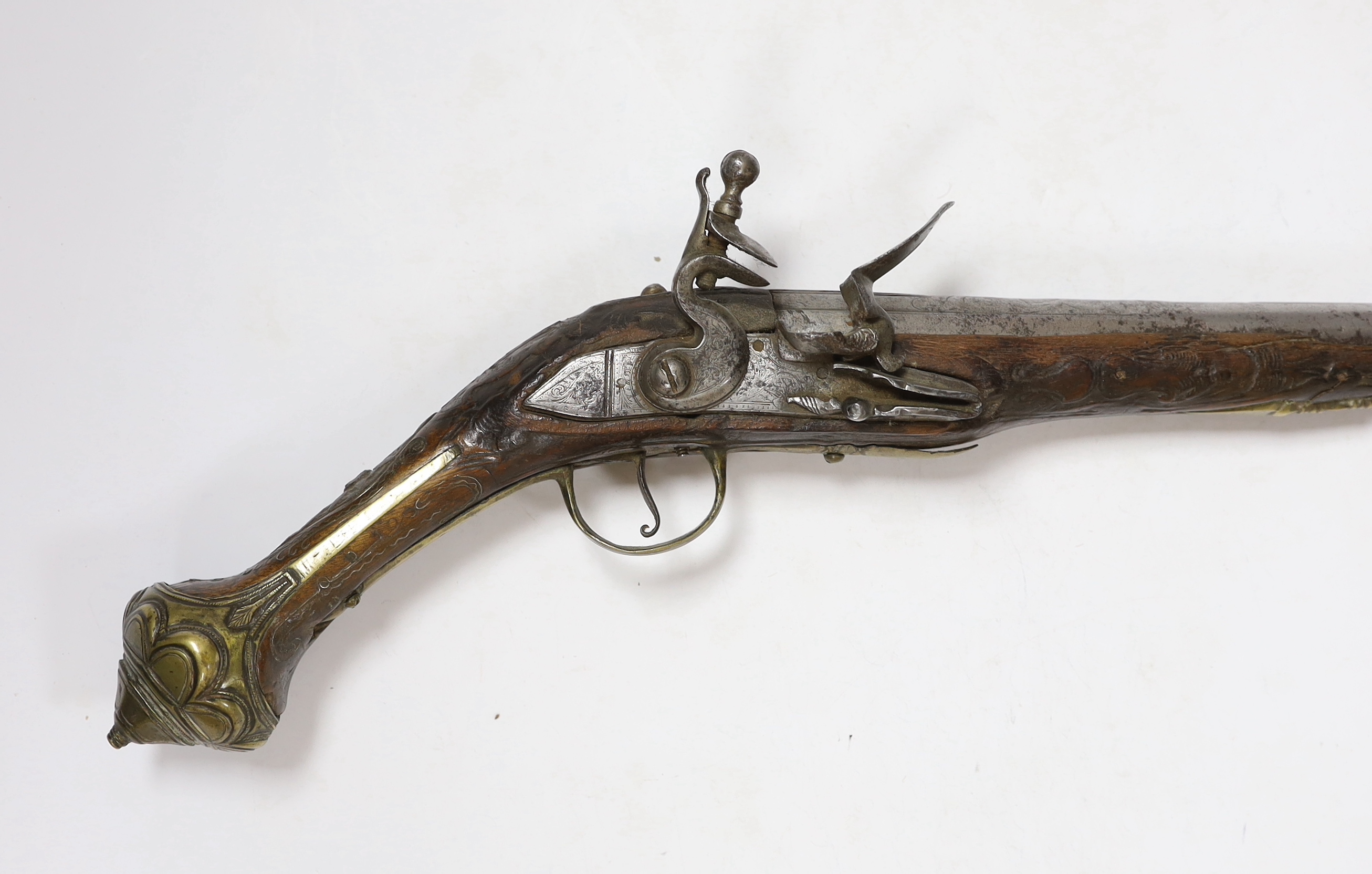 A Turkish Flintlock holster pistol with brass mounts, long spur butt cap, engraved lock and carved stock, barrel 29.5cm